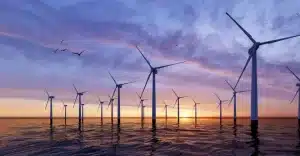 Offshore wind farm at sunset powering IoT networks with renewable energy, symbolizing sustainable connectivity solutions.